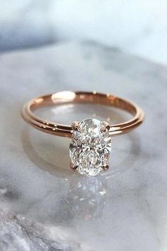 a diamond ring sitting on top of a marble slab