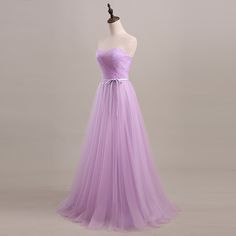 a dress on a mannequin with a purple sash around the waist and straps