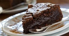 a piece of chocolate cake sitting on top of a plate with a fork in it