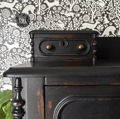 an old fashioned black dresser with brass knobs