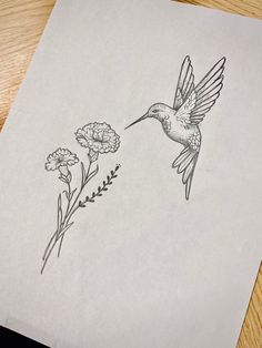 a drawing of a hummingbird flying over flowers on a piece of paper that has been drawn