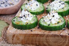 cucumbers with whipped cream and sprinkles on a wooden cutting board