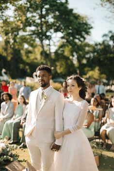 a bride and groom standing next to each other in front of an audience at a wedding