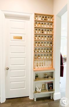 an open door to a room with shelves full of jars