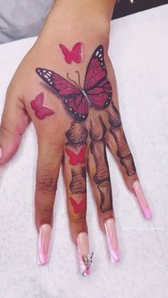 a woman's hand with pink and red butterflies on it, while she has her fingers painted