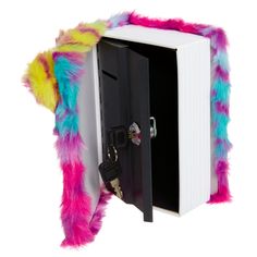 an open book with colorful fur on the cover and key in it's mouth