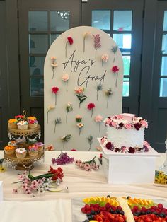 a table topped with lots of different types of cakes and flowers on top of it