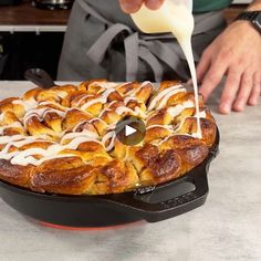 a person pouring milk on top of a pastry