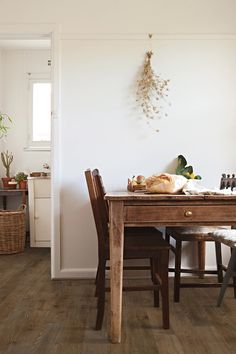 a dining room table and chairs in front of a white wall