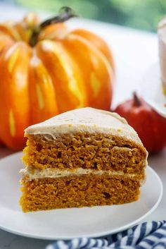 the best pumpkin cake with cinnamon frosting on a white plate next to some pumpkins