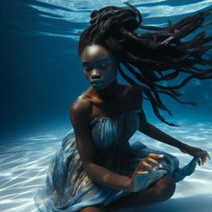 a woman with long hair sitting in the water