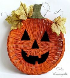 a woven pumpkin basket with leaves on the top and an evil face carved into it