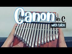 a person holding a wooden comb with the words canon in c on it