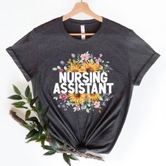 Nursing Assistant Shirt - Soft and comfortable shirt options are made from soft cotton (heather colors also contain polyester). Professionally printed with attention to detail we know our tees will become your favorite. - Soft t-shirts with quality shirt print - Fast customer service - We are here to help answer any questions! - Many different color and size options SIZING INFO Our unisex tees have a regular t-shirt fit. Width and length measurements for all sizes can be seen in the size chart i Heather Grey Graphic Tee With Letter Print, Heather Grey Graphic Tee With Text Print, Heather Grey Cotton T-shirt With Letter Print, Casual Relaxed Fit Nursing T-shirt, Casual Long Sleeve Nursing T-shirt, Assistant Nurse, Cotton Nursing T-shirt With Crew Neck, Crew Neck Cotton T-shirt For Nursing, Cotton Graphic Print T-shirt For Nursing