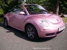 a pink convertible car parked on the street