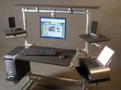 a computer desk with a keyboard, mouse and monitor sitting on it's stand