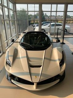 a white sports car is parked in a showroom