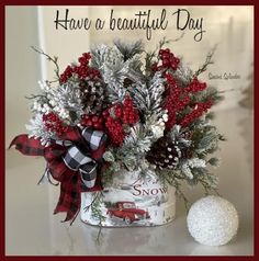 a vase filled with red and white flowers on top of a table next to a christmas ornament