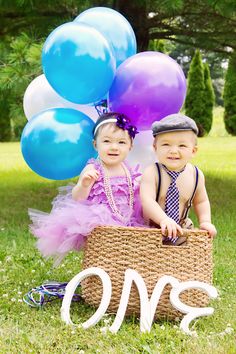 two babies sitting in a basket with balloons