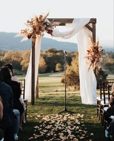 an outdoor ceremony with white drapes and flowers