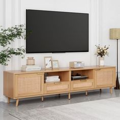 a flat screen tv mounted to the side of a wooden entertainment center in a living room