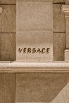 the word versa is written on a stone wall in front of a building with columns