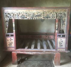 an old wooden bed with floral designs on it