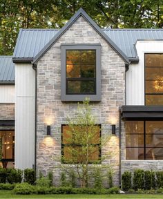 a brick house with two windows on the front and one window in the back that is lit up