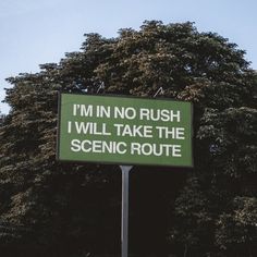 a green sign that says i'm in no rush i will take the scenic route