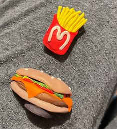 a hot dog and french fries sitting on top of a gray sweater