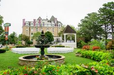 an outdoor wedding venue with chairs and a fountain