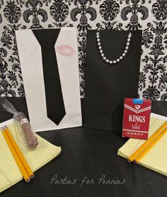 a black table topped with paper bags and yellow pencils