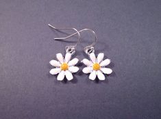 Silver daisy charms (15mm) with white and yellow enamel lacquer, on silver french hook ear wires. These earrings measure one and 1/8 inches in length Same daisies in gold here: https://www.etsy.com/listing/31960845/daisy-earrings-white-and-yellow-enamel See more of my designs here; BohoDreamJewelry.etsy.com And please visit my sister~shops; justCHARMING.etsy.com & justEARRINGS.etsy.com  All of my jewelry shops offer FREE SHIPPING! Highlights: handmade jewelry, daisy earrings, silver charms, whit Adjustable Yellow Daisy Jewelry, Yellow Enamel Earrings, White Daisy Flower Charm Earrings, Yellow Enamel Jewelry With Charms, Yellow Enamel Flower Shaped Jewelry, Daisy Charm, Daisy Earrings, Silver Earrings Dangle, Silver Charms