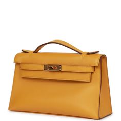 This Mini Kelly Pochette is in Jaune Ambre swift leather with gold hardware and has tonal stitching, front flap, two straps with center toggle closure and a top flat handle. The interior is lined with Jaune Ambre leather and has an open wall pocket. Collection: Y Origin: France Condition: Pristine; new or never Accompanied by: Hermes box, Hermes dustbag, felt, carebook Measurements: 8.5" width x 5" height x 2.5" depth; 1" top handle Hermes Kelly Pochette, Kelly Pochette, Mini Kelly, Open Wall, Hermes Box, Hermes Bags, Wall Pockets, Dress Code, Bags Shoes