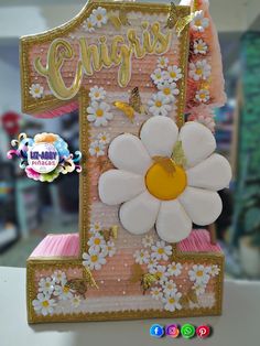 a close up of a cake with flowers and butterflies on the number one frosting