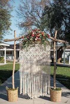 an outdoor wedding ceremony with macrami and flowers