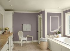 a large bathroom with blue walls and white furniture in the bathtub, sink, and window