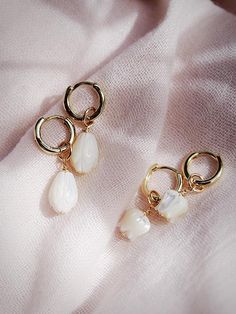 The Lei Hoops reflect Hawaii's natural abundance and beauty. These small gold mother of pearl and gold huggie hoop earrings feature darling carved seashell flower charms reminiscent of Hawai'i's flower leis. These pretty gold hoops are perfect solo or teamed with our some huggie hoops.Handmade on Maui, Hawaii. ✦ Choose from two flower styles: Tulip or Pikake ✦✦ DETAILS ✦✧ Name: Lei (LAEE) - garland.✧ 18kt Gold Vermeil.✧ 25mm & 29mm Drop Length✧ 12mm hoop outer diameter, 9mm inner diameter, & 2.5 White 14k Gold Filled Hoop Earrings, White Dainty Gold-plated Hoop Earrings, White Huggie Earrings As Gift, White Drop Huggie Earrings, White Gold Plated Dainty Hoop Earrings, Gold Plated Huggie Jewelry With Pearl Charm, Small Hoop Jewelry With Dangling Charms For Gifts, White Hypoallergenic Huggie Jewelry, Hypoallergenic White Huggie Jewelry