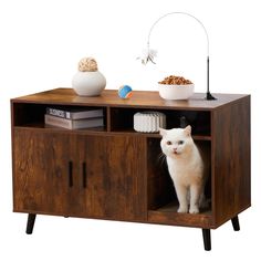 a white cat sitting on top of a wooden cabinet next to a bowl of cereal