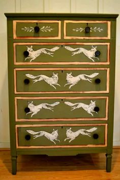 a green dresser with white dogs painted on it