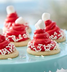 red and white cookies with marshmallows on top are sitting on a blue plate