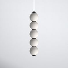 three white balls hanging from a black cord on a light fixture in an empty room