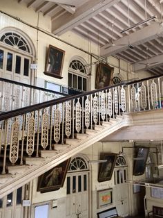 an old building with stairs and pictures on the wall, along with other antique decor