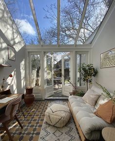 a living room filled with lots of furniture under a glass roof over a dining area