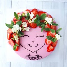 a pink cake decorated with strawberries and flowers