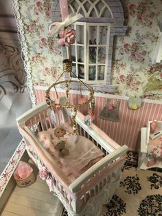 a doll house with a baby crib and teddy bear in the beddings