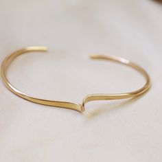 Crafted from 14k gold-filled material, this cuff boasts a curved detail for a unique look and is designed to fit most wrist sizes. 14k gold-filled cuff Featuring a curved detail One size fits most Adjustable 14k Gold Cuff Bracelet, Minimalist Curved Gold Jewelry, Classic Adjustable Gold-plated Cuff Bracelet, Dainty 14k Gold Cuff Bracelet, Adjustable 14k Gold Cuff Bracelet For Everyday, Gold Minimalist Open Band Cuff Bracelet, Gold Open Band Cuff Bracelet Minimalist Style, Gold Curved Jewelry With A Modern Twist, Gold Jewelry With A Modern Curved Design