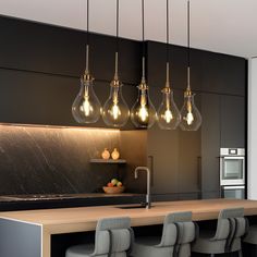 a kitchen with several lights hanging from the ceiling and four stools in front of it