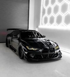 a black sports car parked in front of a garage door