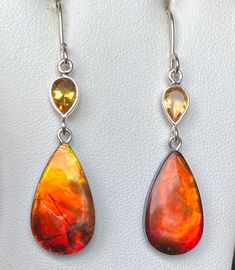 This is a pair of flashy red/orange Ammolite earrings with citrine accents in sterling surrounds.  They are a good match, but one gem has more red along with the orange, and the other a tad more gold.  They are a pretty good match!  The gemstones are 22mm x 12mm and have a thin coating.  They color change to green at extreme angles.  They hang from sterling silver pins and earwires.  They are not overly heavy.  Please remember that I offer combined shipping. Red Orange Color, Citrine, Orange Color, Color Change, Jewelry Earrings Dangle, Dangle Drop Earrings, Dangle Earrings, Jewelry Earrings, Prom